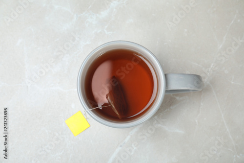 Cup of delicious hot tea on grey background, top view