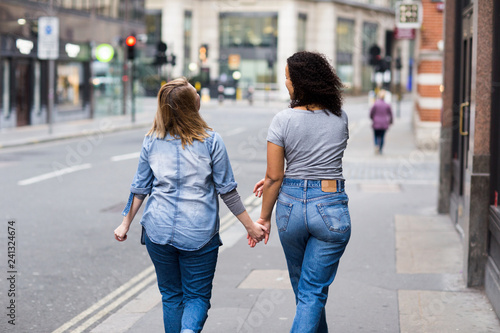 Lesbian couple walking together holding hands