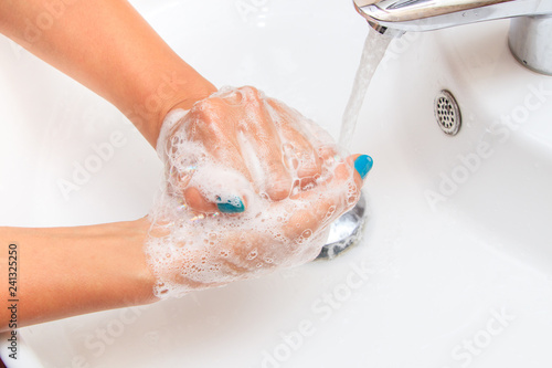 Soaped woman hands in the sink