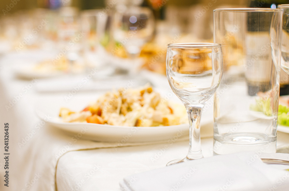 Table set with glass glasses in a restaurant before dinner.