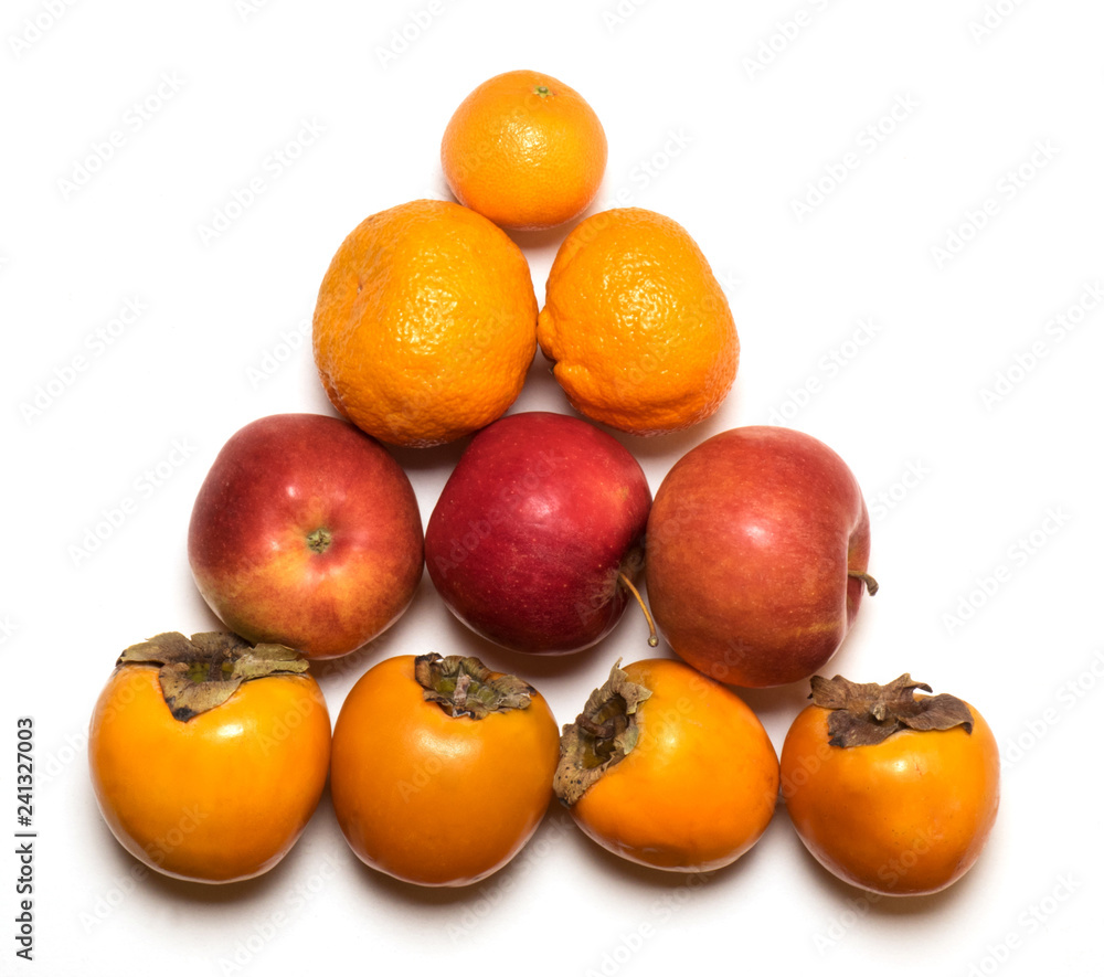 Fruits tangerines, apples and persimmon on a white background in the form of a triangle Fruits tangerines, apples and persimmon on a white background in the form of a triangle