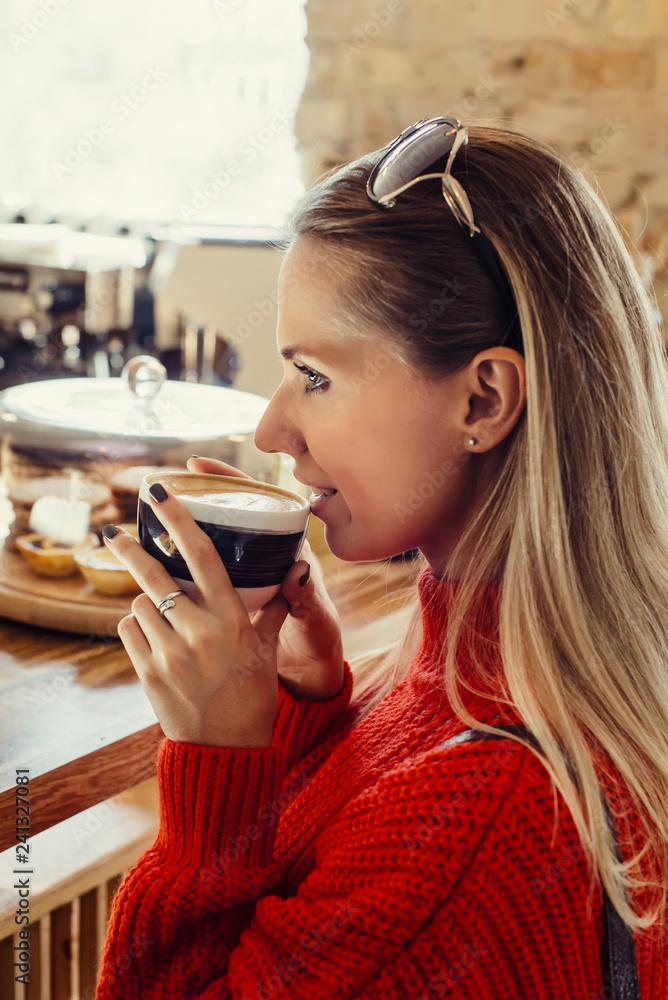 Happy woman enjoying some coffee in a cafeteria
