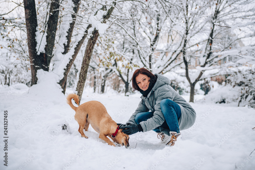 Woman with a dog on a snow