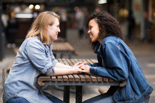 Tablou pe pânză Happy lesbian couple sitting together talking