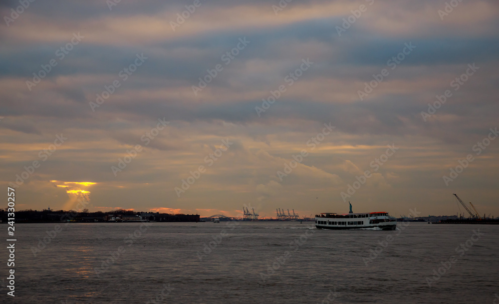 Container cranes in New York harbour at sunset and Statue of Liberty