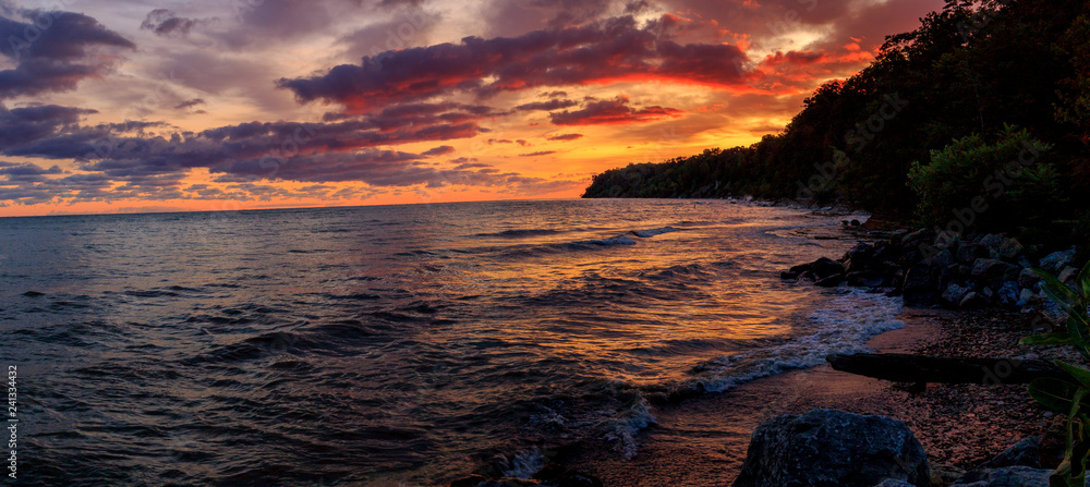 Dramatic sunrise along the shores of Lake Erie. Amazing color reflection from the sun and clouds. 