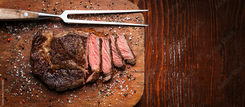 tasty and fresh, very juicy ribbey steak of marbled beef, on a wooden table.