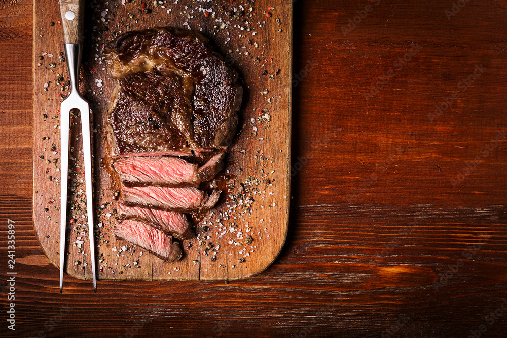 tasty and fresh, very juicy ribbey steak of marbled beef, on a wooden table.