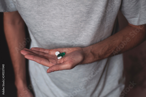 man holds pills in his hand