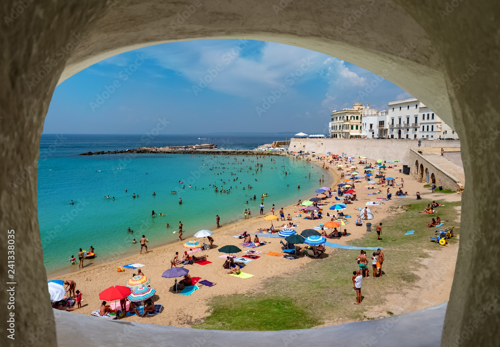 Wide view of the coastline of Ionian sea and people on the beach in summertime in Gallipoli, Lecce region of Italy Wide view of the coastline of Ionian sea and people on the beach in summertime in Gallipoli, Lecce region of Italy