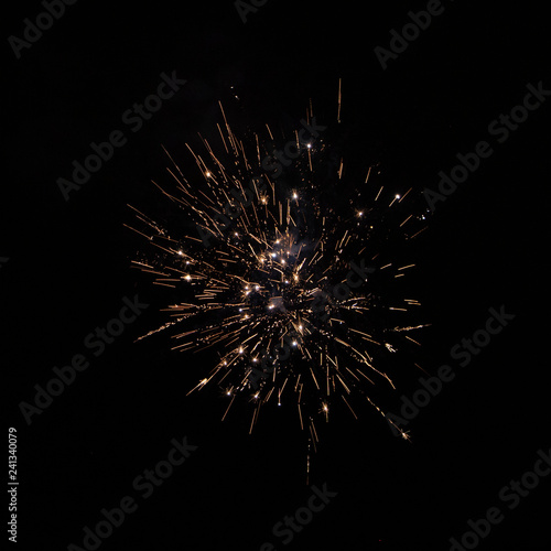 Yellow orange firework against night sky close up