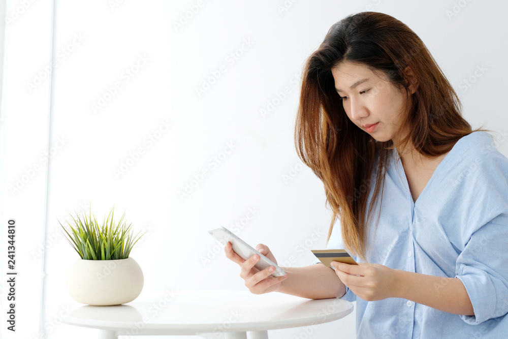 Young asian woman holding credit card and using smart phone for shopping online, business and technology concept, online payment, digital money Young asian woman holding credit card and using smart phone for shopping online, business and technology concept, online payment, digital money