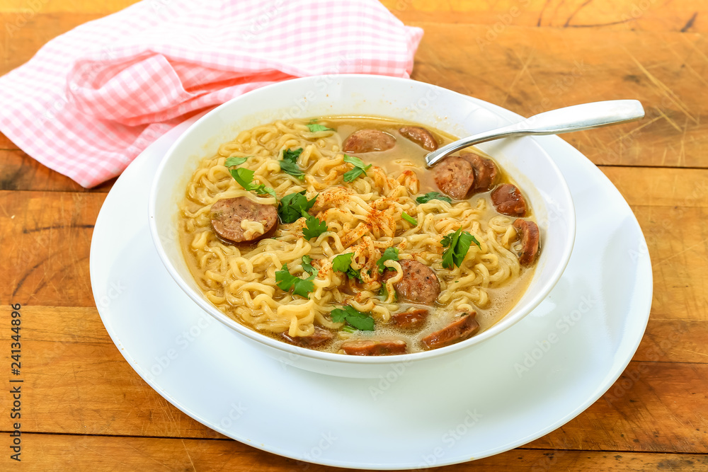 Ramen Noodles with Sausage on Rustic Wooden Table in Strong Backlight Ramen Noodles with Sausage on Rustic Wooden Table in Strong Backlight