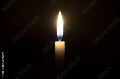 Obraz na plátně A single candle light glowing on a white candle in the middle part of frame on b