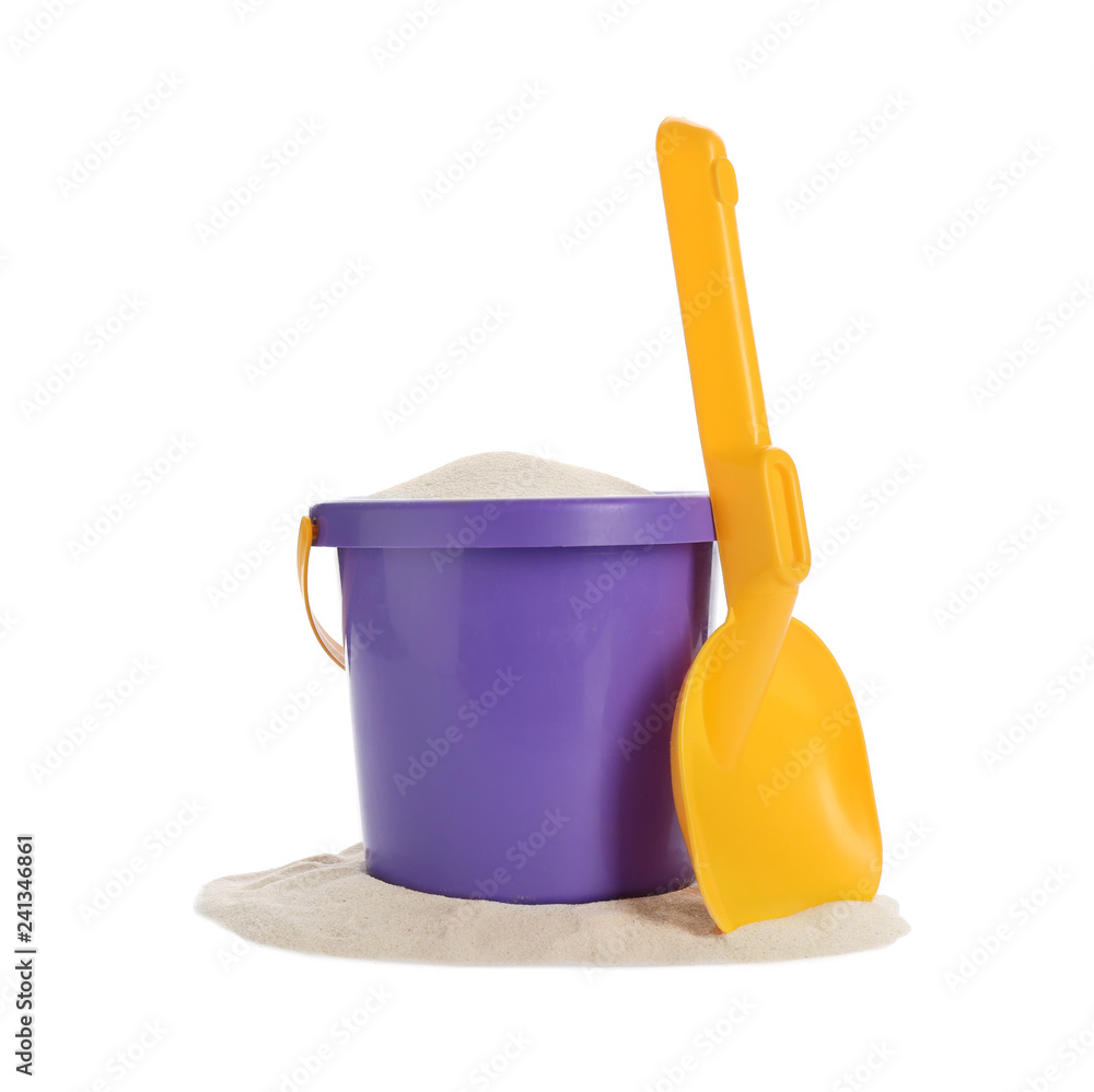 Plastic beach toys on pile of sand against white background Plastic beach toys on pile of sand against white background