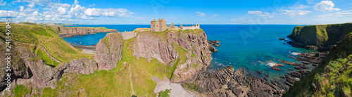 Fototapeta Naklejka Na Ścianę i Meble -  Panorama of a cliff with ancient castle in a bay with blue sky and white clouds in Dunnottar Castle, near Stonehaven, Aberdeenshire