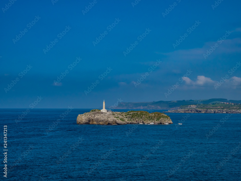 Santander / Hiszpania - 14 lipca 2018: Widok na Latarnię morską na wyspie Mouro z Półwyspu La Magdalena - Santander w słoneczny lipcowy dzień
