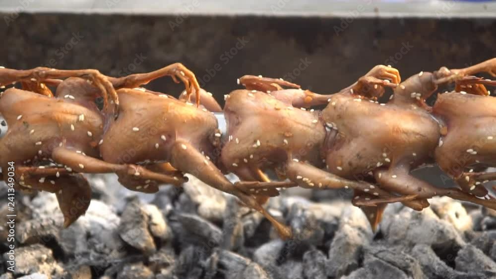 Roasting quails on wheel, close up, street food in Bangkok, Thailand. slow motion. Roasting quails on wheel, close up, street food in Bangkok, Thailand. slow motion.