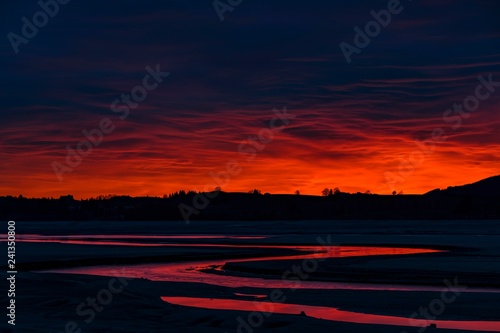 Blue hour with red sky and red reflection in Lech river, Forggensee, Fussen, Ostallgau, Bavaria, Germany, Europe