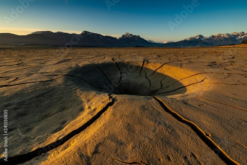 Cracky, dried out soil and Allgau Alps in the background at sunrise, Forggensee, Fussen, Ostallgau, Bavaria, Germany, Europe