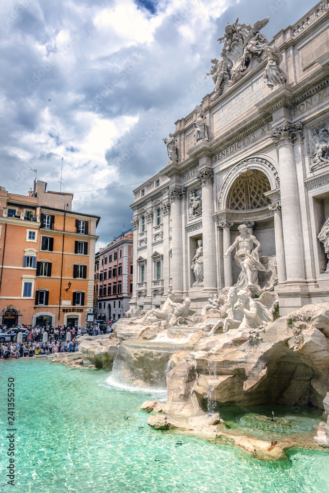 Rome, Italy - May 17th 2018 - Big group of people enjoying a hot day at PIAZZA OF TREVI FOUNTAIN with overcast sky