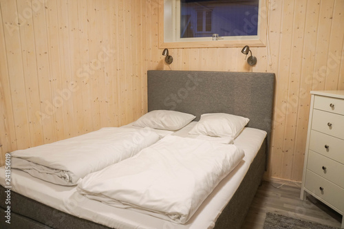 white bedding and comfy pillow in wooden cabinet in bedroom