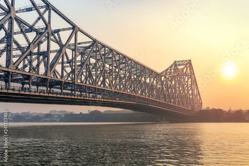 фотографія Howrah bridge Kolkata on river Ganges at sunrise with winter haze