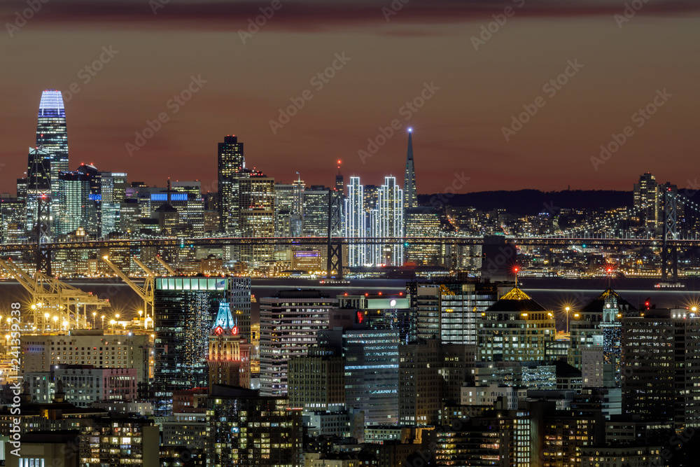 Oakland and San Francisco Twilight Skylines Illuminated with Holiday Lights. Shot on 2019 New Year's Eve from Oakland Hills, California, USA.