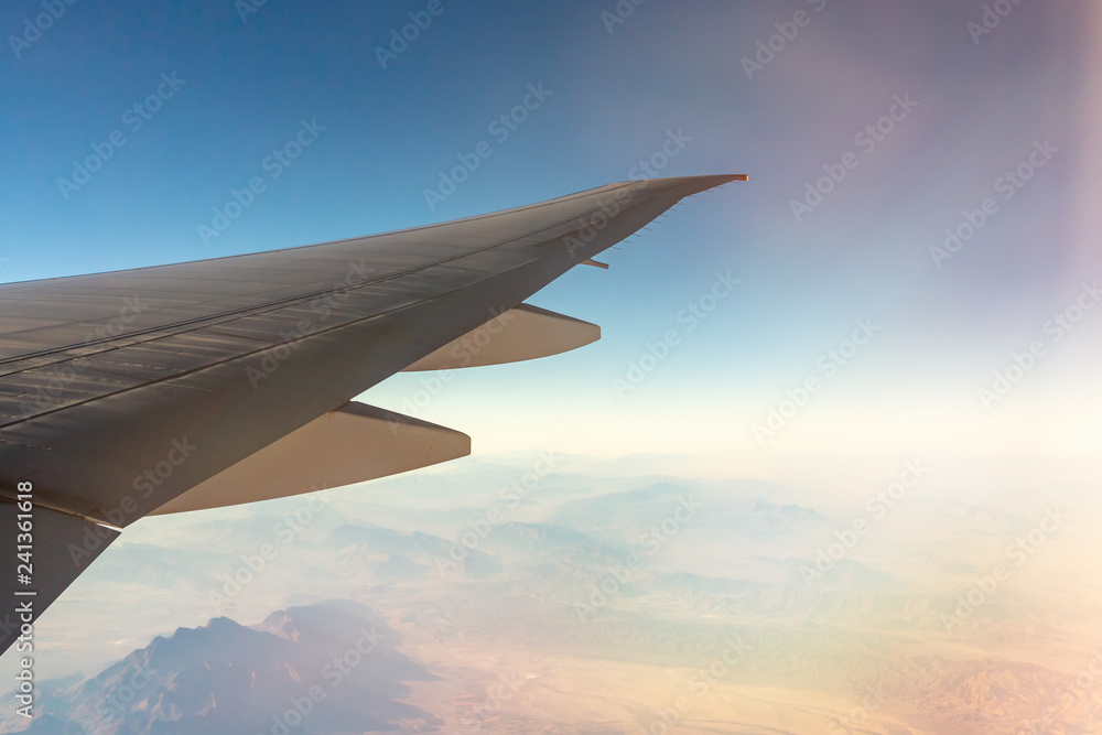 Obraz premium Clouds under the wing of an airplane. Amazing view from the window of the airplane during the flight