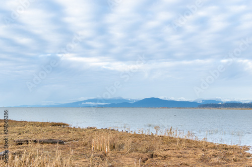 Landscape of coastal mountains and UBC Endowment Lands as seen from Richmond, BC