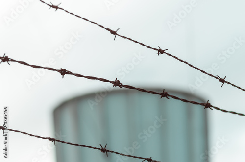 Barbed wire with blurred tower in background