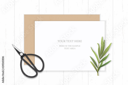 Flat lay top view elegant white composition paper kraft envelope tarragon leaf and vintage metal scissors on wooden background