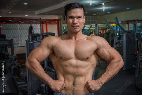 personal fitness trainer show his muscles or Strong bald bodybuilder with six pack