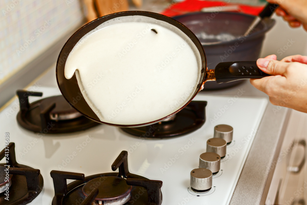 Closeup of cooking pancakes on a gas stove.