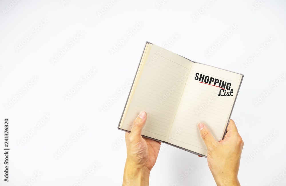 Shopping list text on open note book with hands opening on white background Shopping list text on open note book with hands opening on white background