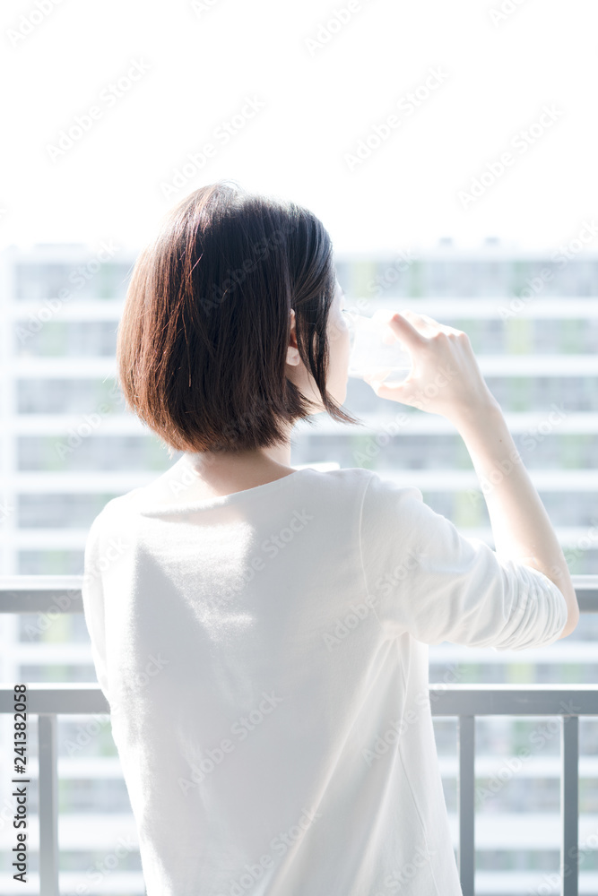  female drinking water on balcony
