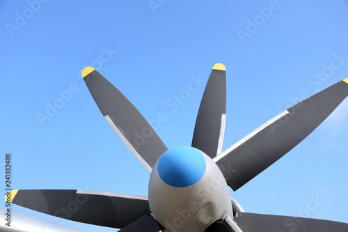 propeller blade of an airplane on blue sky background. Metal black blade of vintage plane. Part of retro airliner. Aviator transport industry. Rotor turbine of an old airplane. Jet engine