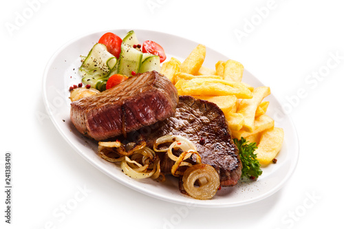 Grilled beefsteak with french fries and vegetable salad on white background