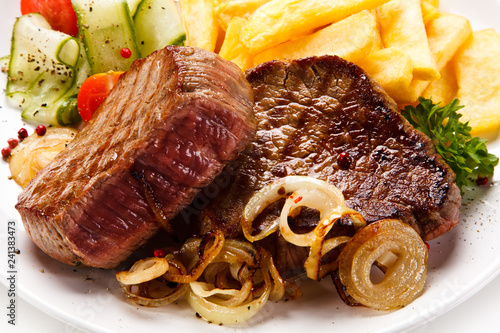 Grilled beefsteak with french fries and vegetable salad on white background