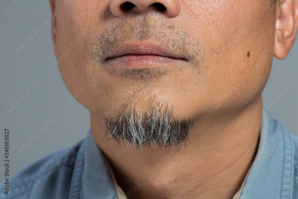 Obraz premium Closeup macro Man grey bread, Human male show close up white black short bread under chin. Body Part of shaved trimmer Mustache 40s age, rear side view background