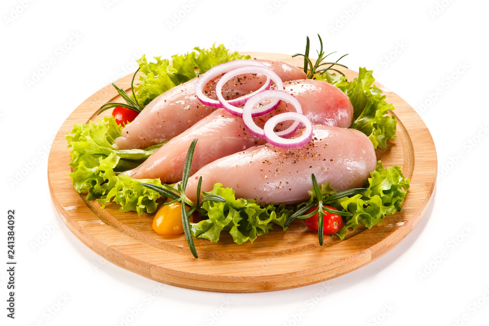 Fresh raw chicken fillet on wooden cutting board on white background Fresh raw chicken fillet on wooden cutting board on white background