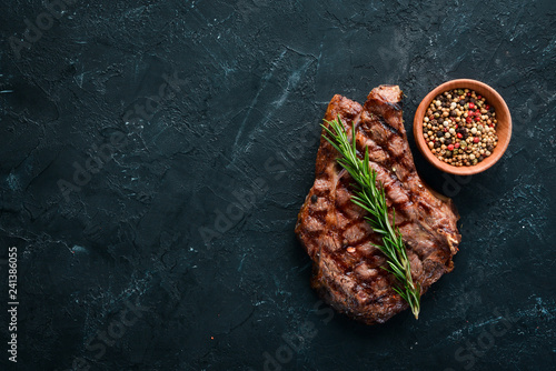 Foto Veal steak on a bone on a black background