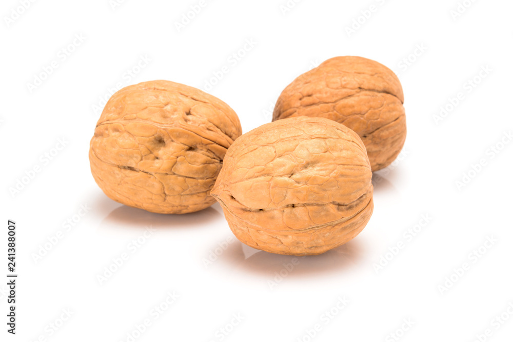 Three whole walnuts, close up macro, isolated on a white background. Three whole walnuts, close up macro, isolated on a white background.