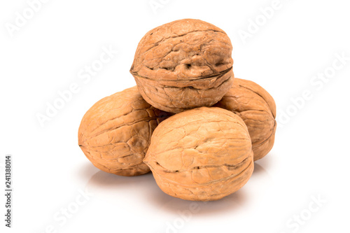 Four whole walnuts, close up macro, isolated on a white background.