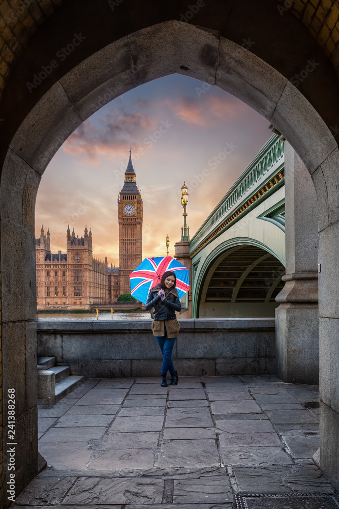 Fototapeta premium Turystka cieszy się widokiem Pałacu Westminsterskiego w Londynie podczas krótkiego wypadu do miasta w Wielkiej Brytanii
