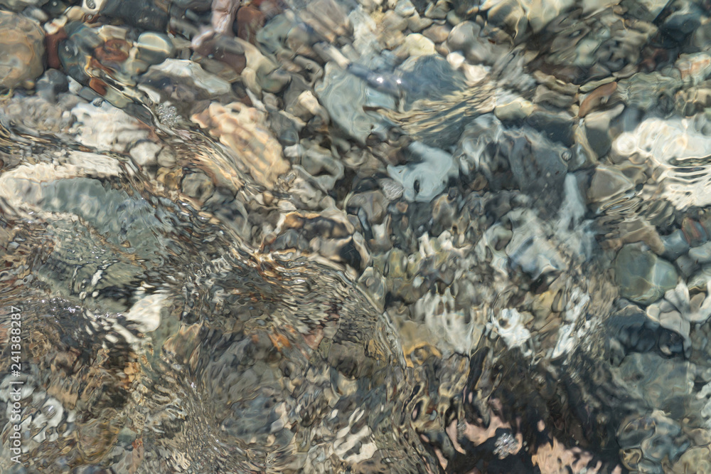 Clear water and colorful pebbles on the sea Clear water and colorful pebbles on the sea