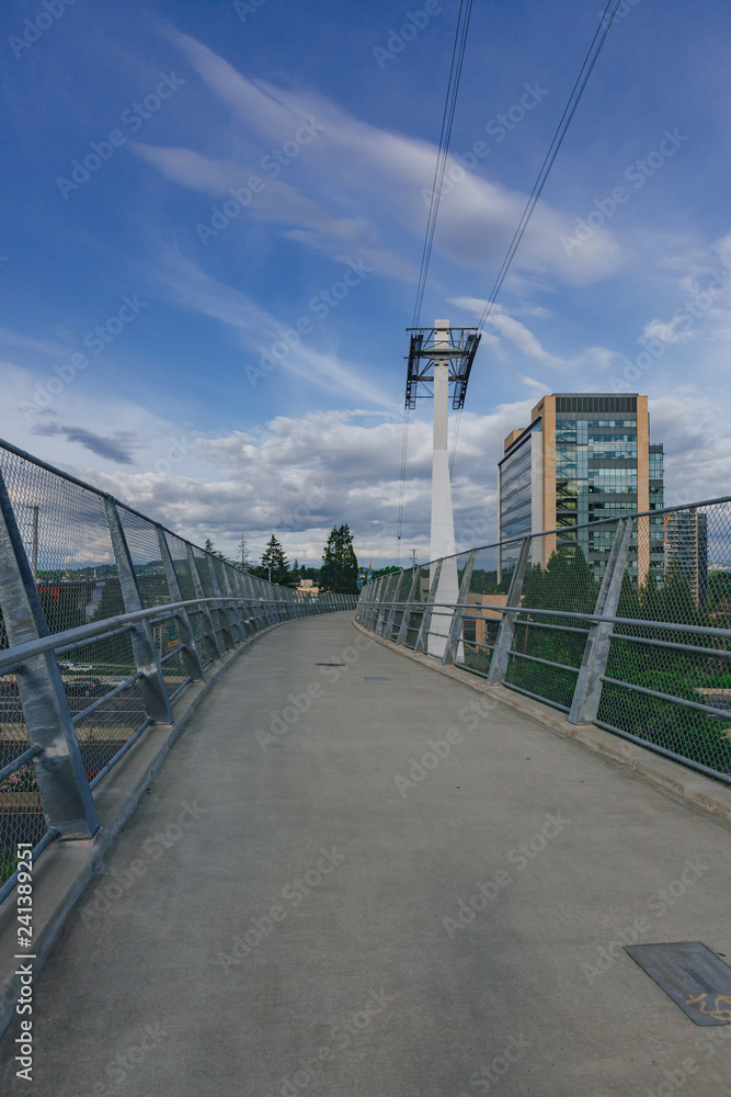 Footpath and aerial tram tower under blue sky in Portland, USA
