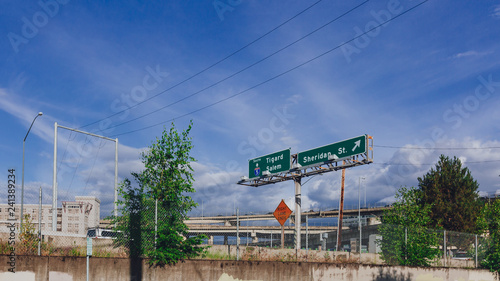 Highways and road signs under blue sky near downtown Portland, USA photo