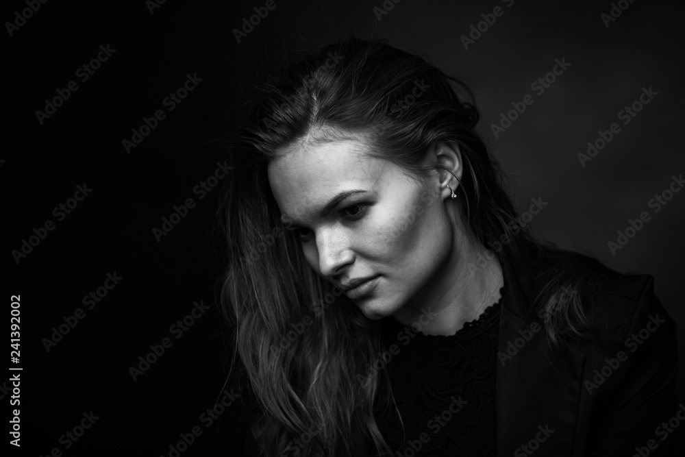 Dramatic black and white portrait of a beautiful girl on a dark background