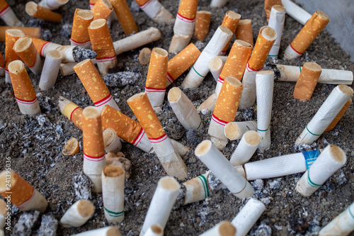 Close up cigarette stub of many in ashtray